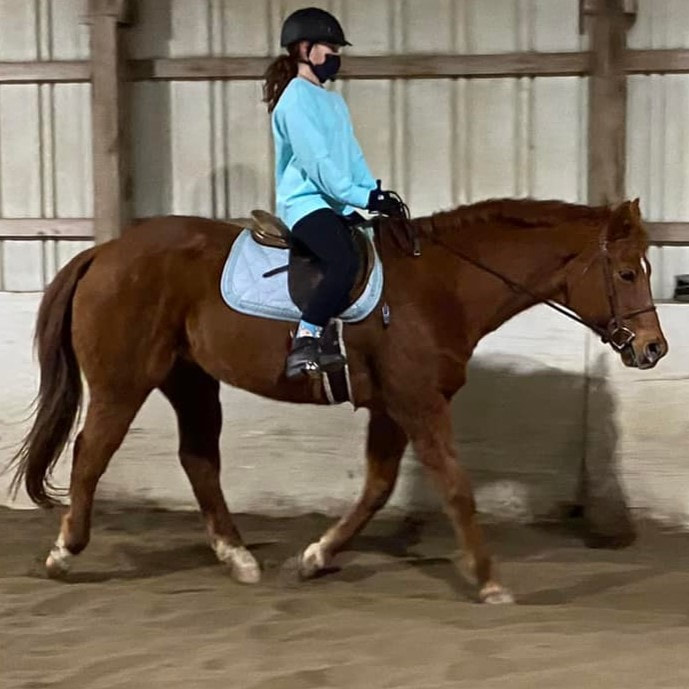 student riding in the indoor arena