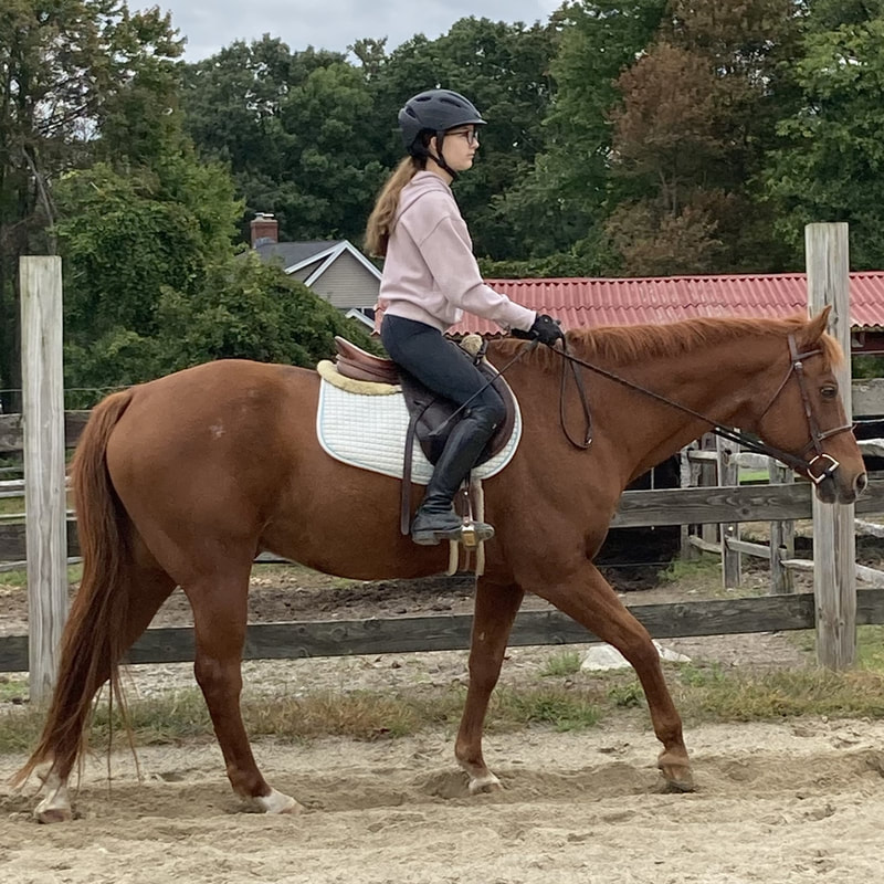 student riding in the outdoor ring